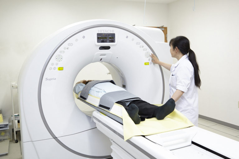MRI検査室で患者をスキャンする医療スタッフ。医療設備と検査風景。